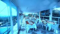 a restaurant with tables and chairs on a balcony at Hotel spa la buena vida in Fusagasuga