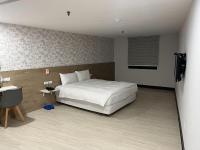 a bedroom with a white bed and a television at Tie Dao Hotel in Tainan