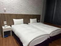 two beds sitting next to each other in a room at Tie Dao Hotel in Tainan