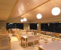 una sala da pranzo con tavoli, sedie e luci di Hodakaso Yamano Hotel a Takayama