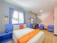 a bedroom with a bed and two blue chairs at Ocean Star B&amp;B in Kenting