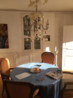 a dining room with a blue table with chairs and a chandelier at Le Magnolia in La Rochefoucauld