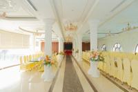 un salón de banquetes con sillas blancas, mesa y flores en Hòa Nam Hotel, en Nam Dương