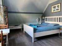 a bedroom with a bed with blue sheets and blue pillows at le gîte de Martine en Baie de Somme in Lanchères