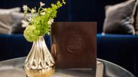 a table with a vase of flowers and a brown card at The Wellem, in The Unbound Collection by Hyatt in Düsseldorf