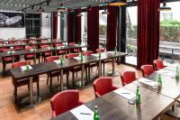 a restaurant with wooden tables and red chairs at The Wellem, in The Unbound Collection by Hyatt in Düsseldorf