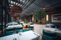 a restaurant with white tables and blue chairs at The Wellem, in The Unbound Collection by Hyatt in Düsseldorf