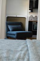 a blue couch in a room with a kitchen at Best place à 15 min de Paris in Saint-Maur-des-Fossés