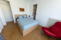 a bedroom with a bed and a red chair at Best place à 15 min de Paris in Saint-Maur-des-Fossés