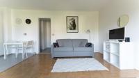 a living room with a couch and a tv at Best place à 15 min de Paris in Saint-Maur-des-Fossés