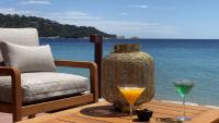 a table with a vase and two drinks on it at Surplage Hotel Cavalière in Le Lavandou