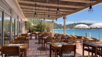 a restaurant with tables and chairs and a view of the water at Surplage Hotel Cavalière in Le Lavandou