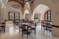 a dining room with tables and chairs and windows at JAZ Makadina in Hurghada