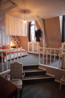 a bedroom with stairs leading to a bed and a chair at MAISON RENARD in Béthune