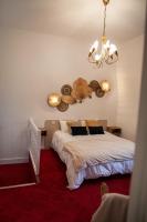 a bedroom with a bed and a chandelier at MAISON RENARD in Béthune