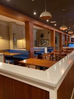 a dining room with wooden tables and blue chairs at Hotel Las Palmas Inn in Punto Fijo