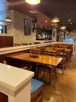 a restaurant with wooden tables and chairs and a bar at Hotel Las Palmas Inn in Punto Fijo