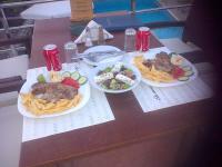 a table with three plates of food and fries at Ela Mesa in Souvala