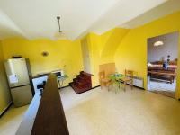 a kitchen with yellow walls and a table and a refrigerator at Maison Pradons, 4 pièces, 6 personnes - FR-1-697-24 in Pradons