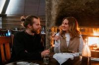 a man and woman sitting at a table eating food at Arctic SnowHotel & Glass Igloos in Sinettä