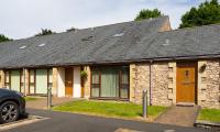 ein Steinhaus mit einem davor geparkt in der Unterkunft Tewitfield Marina in Carnforth