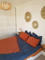 a bedroom with a bed with orange and blue pillows at Appart neuf entre Paris et Versailles, A 5 mn école Ducasse in Meudon
