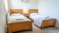 2 Einzelbetten in einem Zimmer mit 2 Tischen in der Unterkunft Tewitfield Marina in Carnforth