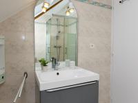 a bathroom with a sink and a mirror at Holiday Home Coquelicot by Interhome in Saint-Méloir-des-Ondes