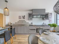 a kitchen with gray cabinets and a table and chairs at Holiday Home Saint-Colomban-2 by Interhome in Carnac