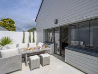 a patio with a table and wicker chairs at Holiday Home Saint-Colomban-2 by Interhome in Carnac