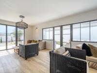 a living room with couches and chairs and windows at Holiday Home Saint-Colomban-2 by Interhome in Carnac