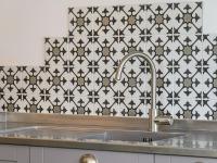 a kitchen sink with a black and white tiled wall at Holiday Home Saint-Colomban-2 by Interhome in Carnac