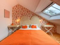 a bedroom with an orange bed in a attic at Holiday Home Saint-Colomban-2 by Interhome in Carnac