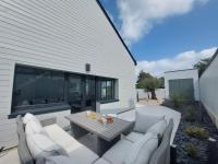 a patio with white couches and a table at Holiday Home Saint-Colomban-2 by Interhome in Carnac