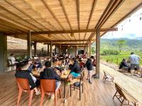 un grupo de personas sentadas en una mesa en un restaurante en Chipau Homestay Trạm Tấu, en Cham Ta Lao