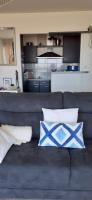 a couch with blue and white pillows in a living room at Sur le sable 2 3 pers WIFI in Boulogne-sur-Mer