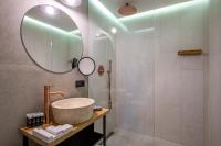 a bathroom with a sink and a shower with a mirror at IOTA Hotel Tbilisi in Tbilisi City