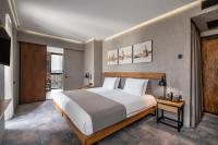 a bedroom with a large white bed and a television at IOTA Hotel Tbilisi in Tbilisi City