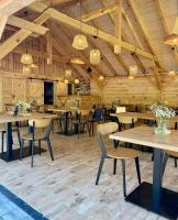 een restaurant met houten tafels, stoelen en verlichting bij Leśne Ustronie in Lubiszewo