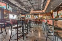 Un bar con sillas y mesas en un restaurante. en Buffalo Airport Hotel, en Cheektowaga