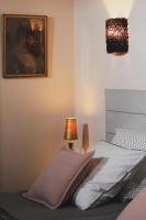 a bedroom with a bed with a lamp next to it at Au bout du pré in Pézenas