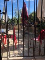 a patio with chairs and tables and an umbrella at Au bout du pré in Pézenas