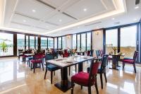 a dining room with tables and chairs and windows at Gloud Hotel in Hanoi