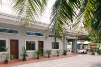 a house with palm trees in front of it at Lea's Guesthouse and Restaurant in Phumĭ Phlov Phnum Pénh