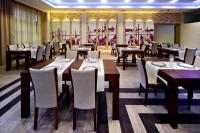 Un restaurante con mesas de madera y sillas blancas. en Mela Verde, en Zakręt