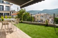 a balcony with a table and chairs and a lawn at Natur in İzmir