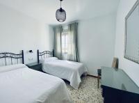 a hotel room with two beds and a mirror at Apartamentos Turísticos Santo Rostro in Chipiona