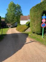 a road with a street sign next to a bush at Le Nid du Cygne in Houlle