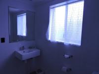a white bathroom with a sink and a window at Acacia Snowy Motel in Jindabyne