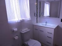 a white bathroom with a toilet and a sink at Acacia Snowy Motel in Jindabyne